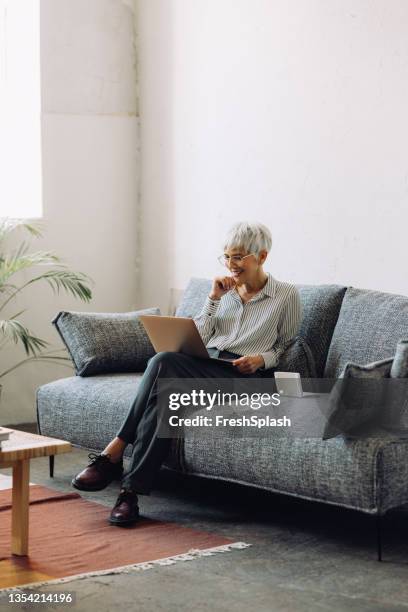 senior woman using laptop computer at home - seat of the european central bank stockfoto's en -beelden