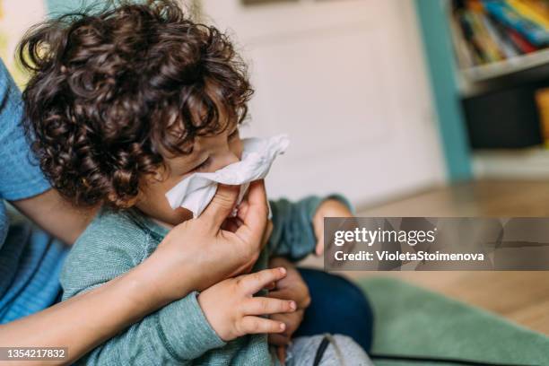 madre ayudando al hijo a sonarse la nariz. - sonarse fotografías e imágenes de stock