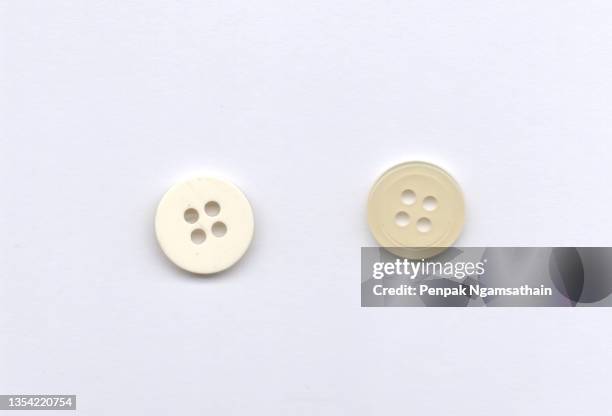 white sewing button circle shape four hole isolated on white background - button white stock-fotos und bilder