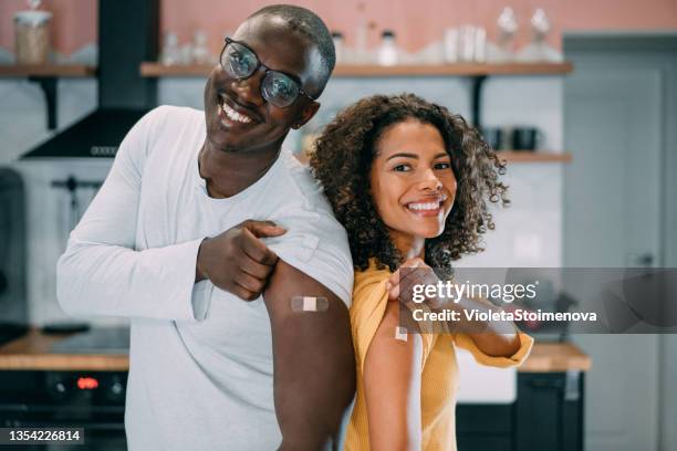 pareja mostrando sus brazos después de vacunarse. - vacuna fotografías e imágenes de stock