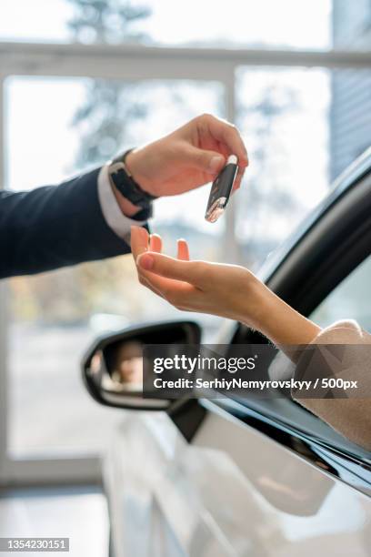 cropped hand of woman giving car key to customer in car - car keys hand ストックフォトと画像