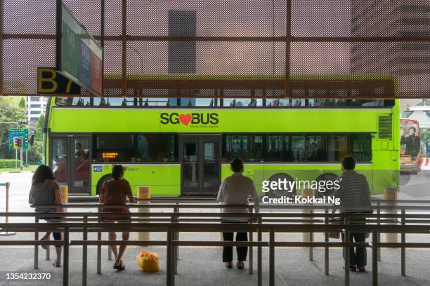 leute, die auf den bus warten, um am jurong east bus interchange anzukommen - west asia stock-fotos und bilder