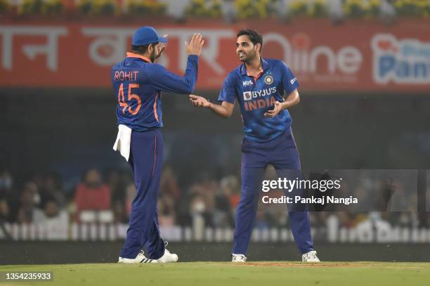 Bhuvneshwar Kumar of India celebrates with teammate Rohit Sharma following the wicket of Jimmy Neesham of New Zealand during the T20 International...