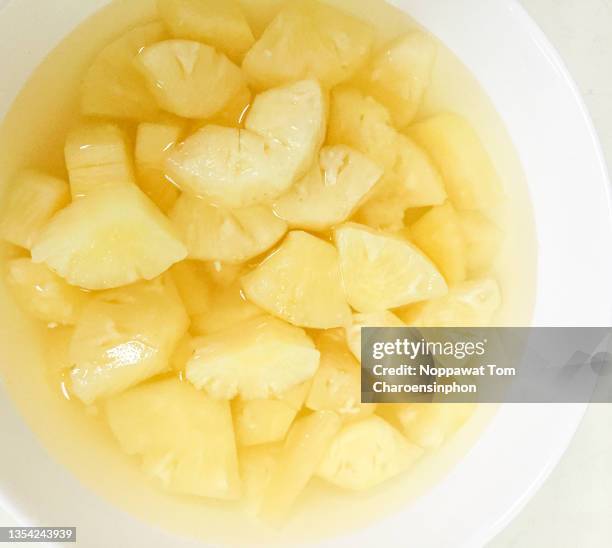 closed-up shot of pineapple pieces in light syrup on the plate, thailand, southeast asia - pineapple cut stock pictures, royalty-free photos & images