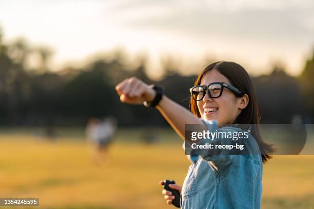junge frau mit smart glasses und sport mit ihren freunden im augmented reality metaverse - asian games day 1 stock-fotos und bilder