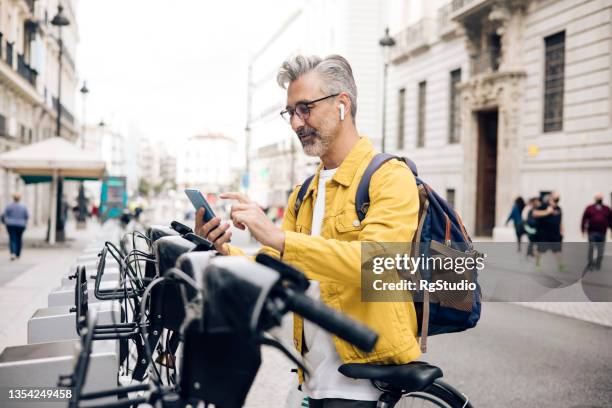 reifer tourist, der ein e-bike mietet - bicycle rental stock-fotos und bilder