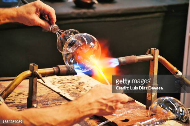 handcrafting process of glass artist. - glass blowing - fotografias e filmes do acervo