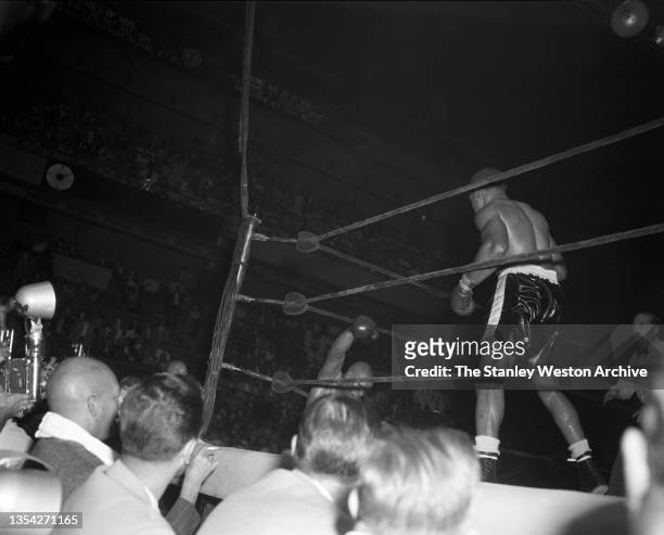 Photo shows Harold Johnson, down in the corner and Archie Moore standing after he knocked out Johnson :56 seconds into the 14th round and winning by...