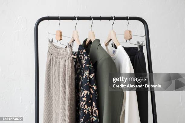 a lot of clothes hanging on the rail white background - kleiderbügel stock-fotos und bilder