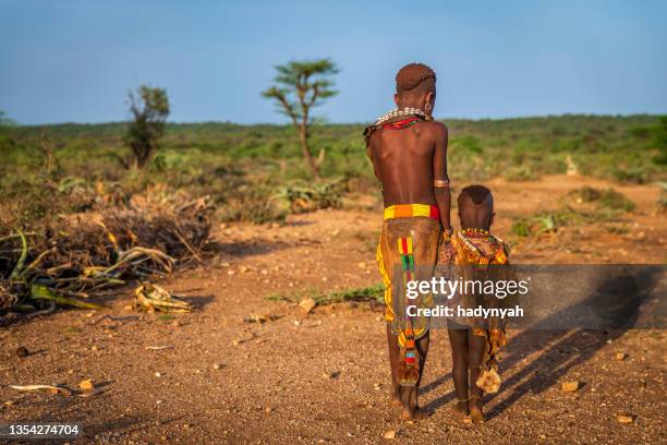 kleines mädchen aus dem hamer-stamm mit ihrer kleinen schwester, äthiopien, afrika - ethiopia stock-fotos und bilder