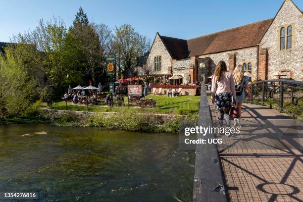 Salisbury, Wiltshire, UK, The River Avon flowing past customers queuing and eating outside Bishops Mill pub during Covid lockdown.