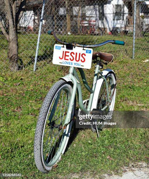 A bicycle with a JESUS license plate sitting in the front yard of