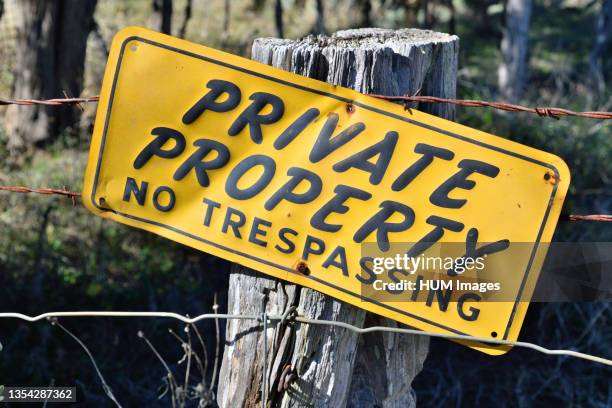 Private Property No Trespassing sign on a fence post along a rural Texas highway.