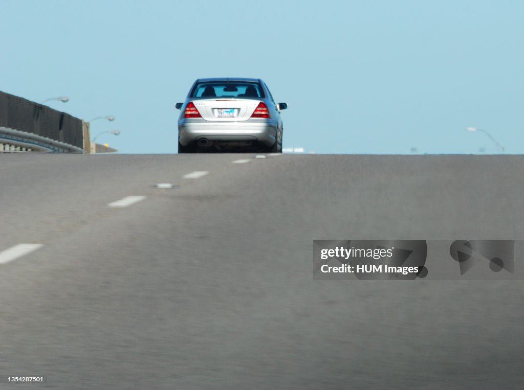 One compact car (silver) in the left lane of a Texas highway
