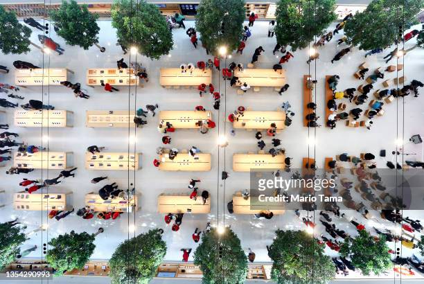 People are reflected in the overhead mirror as they attend the grand opening event of the new Apple store at The Grove on November 19, 2021 in Los...