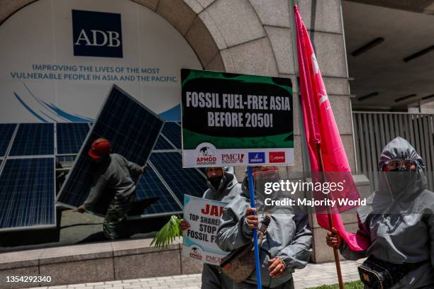 Climate activists dressed in PPE suits protest outside the Asian Development Bank headquarters in Mandaluyong City. The group called on ADB...