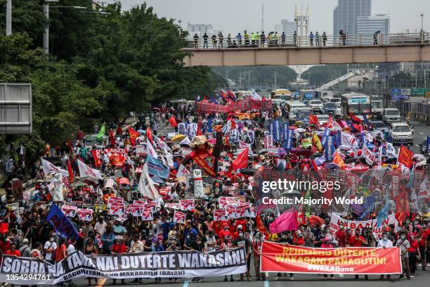 Protesters wearing protective gear march ahead of President Rodrigo Duterte's last state of the nation address in Quezon City, Metro Manila....