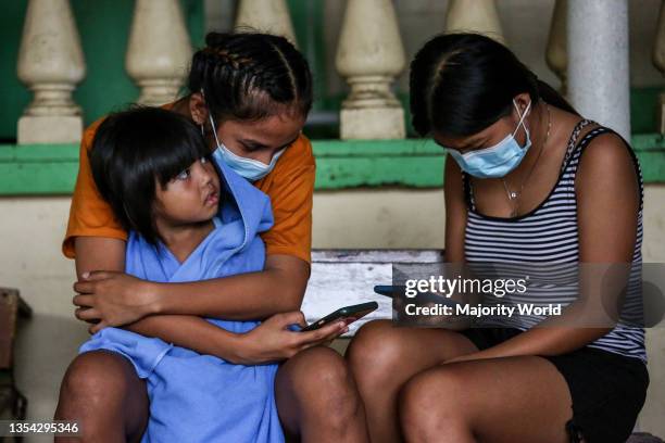 Residents stay inside a school turned into a temporary evacuation center as the Taal volcano releases smoke and ash in Agoncillo town, Batangas...