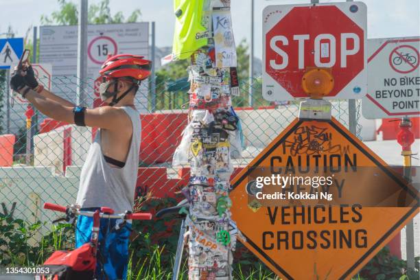 radfahrer macht selfie mit tuas lamp post 1 - singapore grafite stock-fotos und bilder