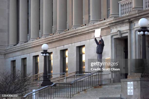 Supporter of Kyle Rittenhouse, holds a sign that says "Free Kyle" outside of the Kenosha County Courthouse hours after learning that Rittenhouse was...