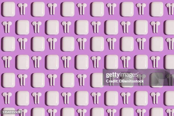 pattern of trendy wireless white headphones on purple background. - computer graphic design headphones stock pictures, royalty-free photos & images