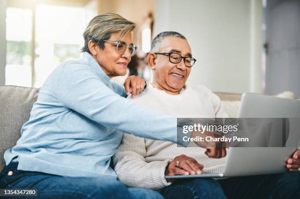 shot of a senior couple using a laptop at home - senior adult on computer stock pictures, royalty-free photos & images