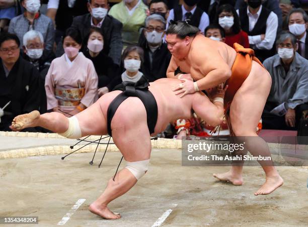 Sekiwake Mitakeumi throws Myogiryu to win on day six of the Grand Sumo Kyushu Tournament at the Fukuoka Convention Center on November 19, 2021 in...