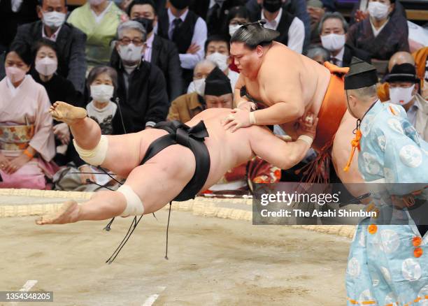 Sekiwake Mitakeumi throws Myogiryu to win on day six of the Grand Sumo Kyushu Tournament at the Fukuoka Convention Center on November 19, 2021 in...