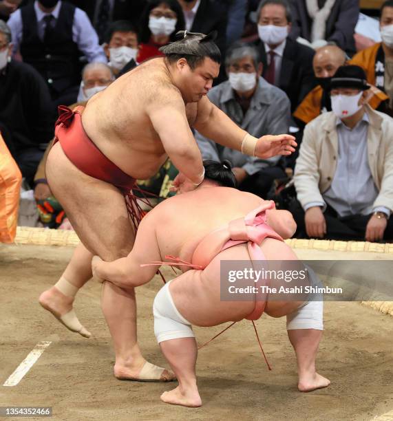 Ura pushes Takayasu out of the ring to win on day six of the Grand Sumo Kyushu Tournament at the Fukuoka Convention Center on November 19, 2021 in...