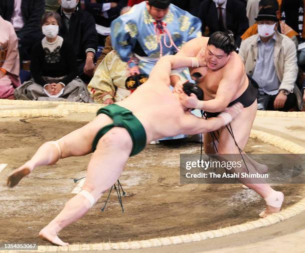 Abi throws Sadanoumi to win on day six of the Grand Sumo Kyushu Tournament at the Fukuoka Convention Center on November 19, 2021 in Fukuoka, Japan.