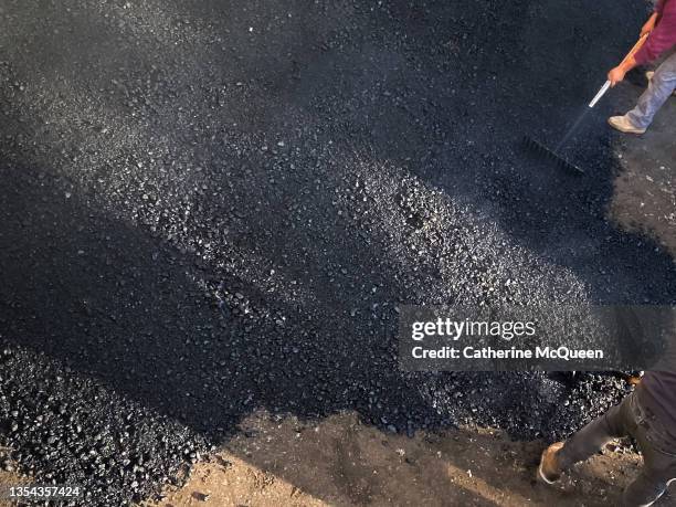 workers spreading hot steaming tar - surface preparation stock pictures, royalty-free photos & images