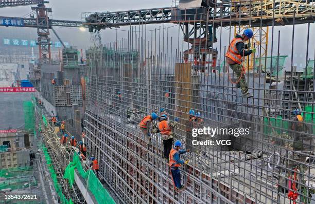 Workers at the construction site of Huangjinxia Reservoir on November 19, 2021 in Hanzhong, Shaanxi Province of China.