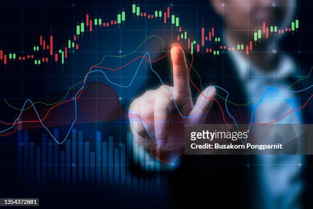 businessman looking at graph on glass pane analyze trends - wisselkantoor stockfoto's en -beelden