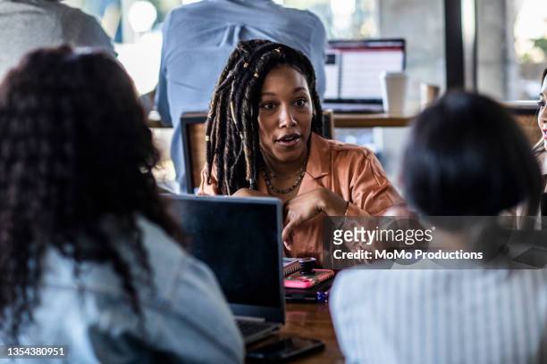 young professional women collaborating in coffeeshop - black business woman bildbanksfoton och bilder