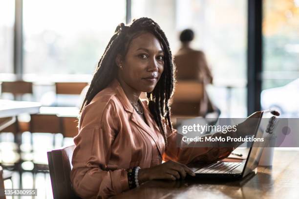 portrait of young professional woman in coffee shop - mature cafe happy stock-fotos und bilder