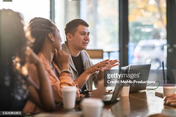 young professionals collaborating in coffeeshop - small group of people stock pictures, royalty-free photos & images