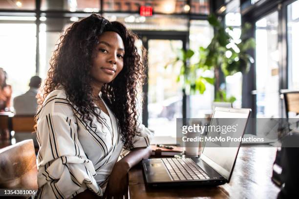 portrait of young professional woman in coffee shop - millennials working ストックフォトと画像