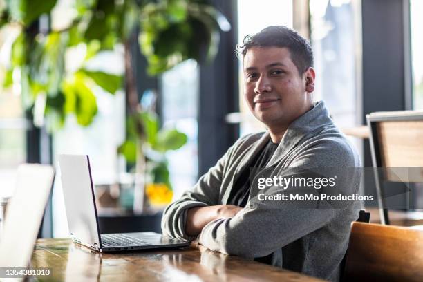 portrait of young professional man in coffee shop - handsome mexican men stock-fotos und bilder