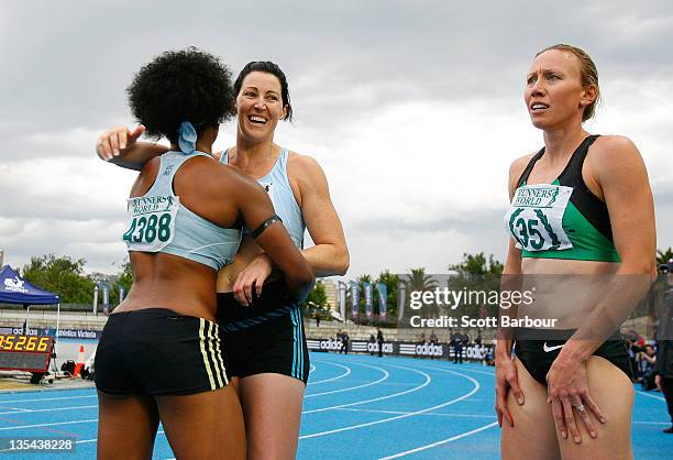 Jana Pittman of Glen Huntly is embraced by a team mate as Tamsyn Lewis of Sandringham looks on after the Victorian 4x400m Womens Final during the...