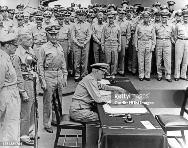 Surrender of Japan - Fleet Adm. Chester W. Nimitz, U.S. Navy, signs the Instrument of Surrender as United States representative, aboard USS Missouri...