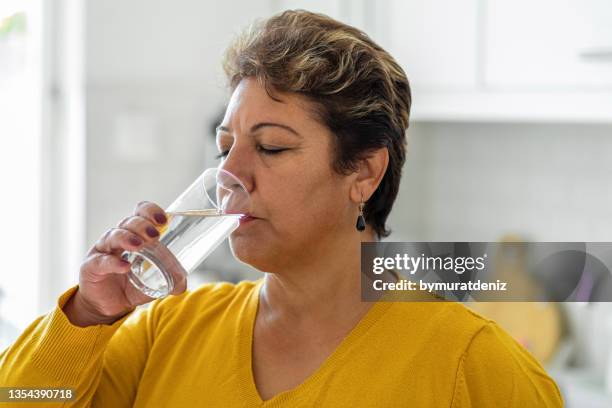 mujer bebiendo de un vaso de agua - thirsty fotografías e imágenes de stock