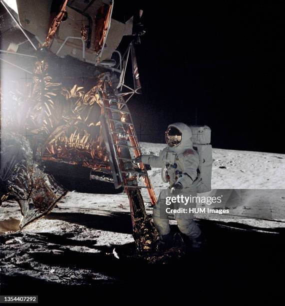 Astronaut Alan L. Bean, lunar module pilot for the Apollo 12 lunar landing mission, steps from the ladder of the Lunar Module to join astronaut...