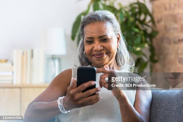 active senior woman uses smartphone - texting stock pictures, royalty-free photos & images