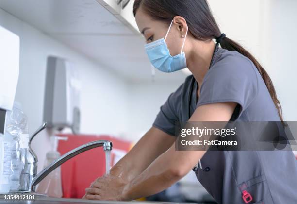 nurse rinsing off her hands - doctor scrubs stock pictures, royalty-free photos & images