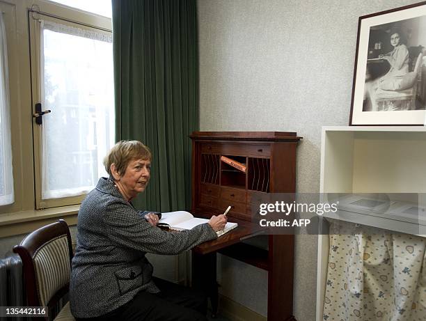 Jaqueline van Maarsen, a friend of Anne Frank, signs the guest book on December 10, 2011 at the Amsterdam apartment where the Jewish teenager and her...