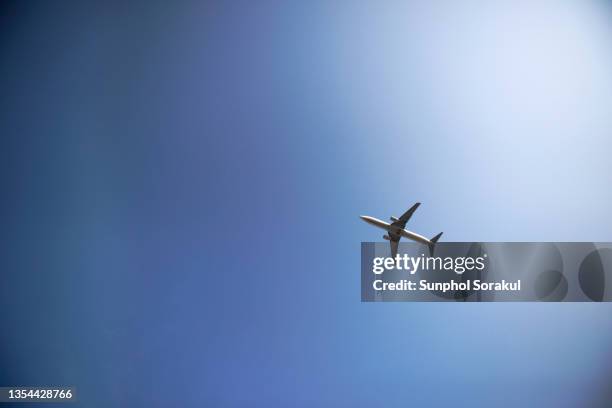 a passenger airplane flyover against the dusk sky - airplane take off stock pictures, royalty-free photos & images