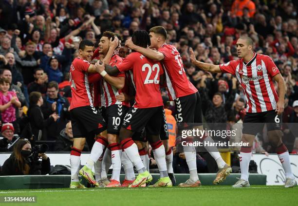 Che Adams of Southampton celebrates with teammates after scoring their team's first goal during the Premier League match between Norwich City and...