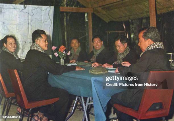 Wearing black peasant garb, chequed krama and with their Chinese military caps resting on the table, from the left closest to the map are Ieng Sary...
