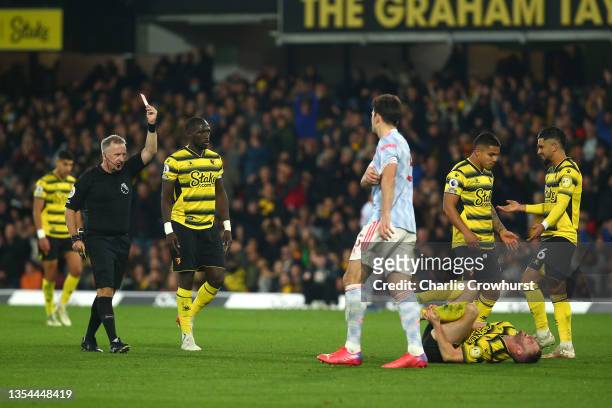 Match referee Jonathon Moss shows a red card to Harry Maguire of Manchester United during the Premier League match between Watford and Manchester...