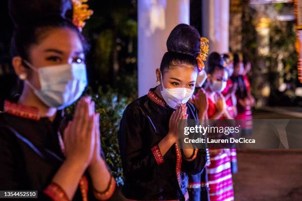 Thai women in traditional costumes welcome visitors to the Yee Peng festival on November 20, 2021 inLamphun, Thailand. The Gassan Panorama Golf...